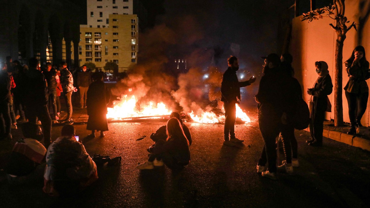 Demonstrators sit by flaming tires cutting off a road in the centre of Lebanon's capital Beirut during a protest against deteriorating economic and social conditions. Credit: AFP Photo