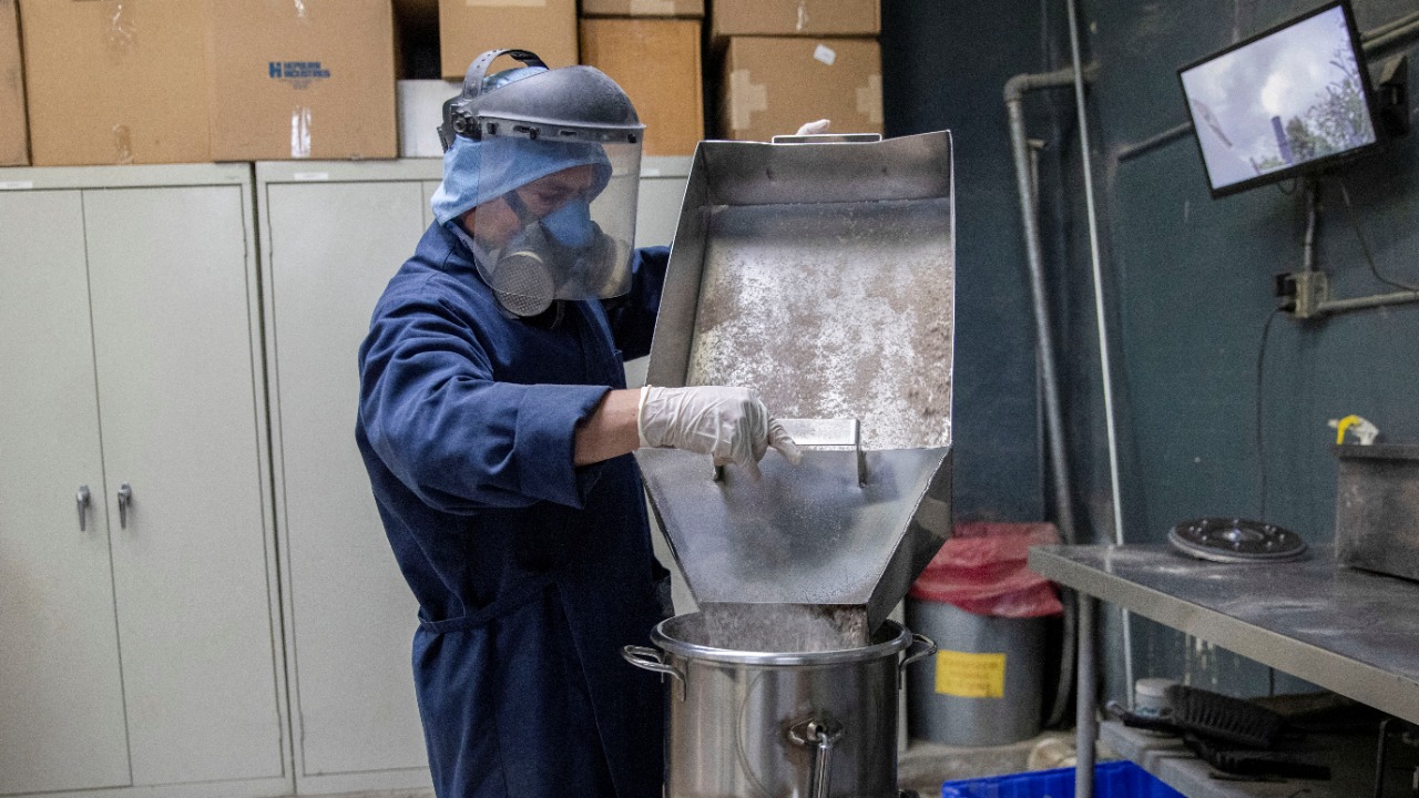 A worker carefully handles the cremated remains at the Hollywood Forever crematorium as it struggles to keep up with demand during the outbreak of coronavirus disease in Los Angeles, California. Credit: Reuters Photo