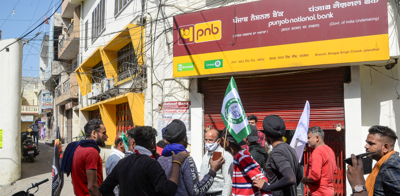 The SKM called for a Bharat Bandh from 6 am to 6 pm, wherein all road and rail transport, markets and other public places were shut across the country. This picture shows people protesting in front of a closed Punjab National Bank branch in Jalandhar. Credit: PTI Photo