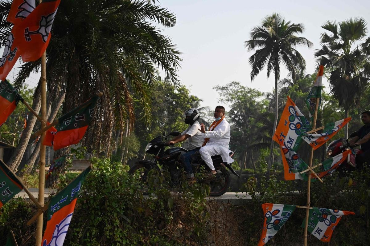 Bharatiya Janata Party (BJP) candidate Suvendu Adhikari (R) leaves on a motorbike after casting his vote at a polling station during Phase 2 of West Bengal's legislative election in Nandigram. Credit: AFP Photo
