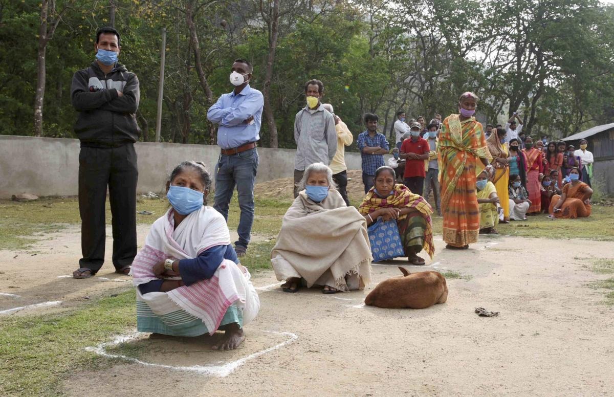Voters maintain social distance as they arrive to cast their votes during the second phase of the Assam Assembly election, at a polling station in Morigaon. Credit: PTI Photo