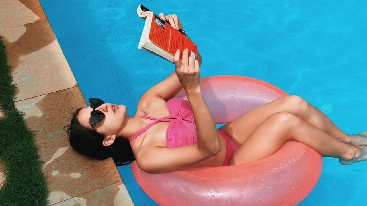 A bright pink halter bikini with blue-hued eyes and statement blue earrings—and we're sold!