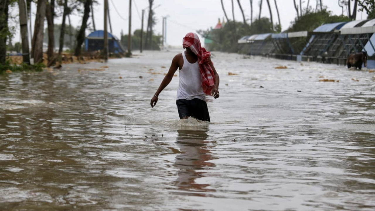 A man wades through a water-logged road after rains ahead of Cyclone Yaas at Digha in Bengal. Credit: Reuters Photo