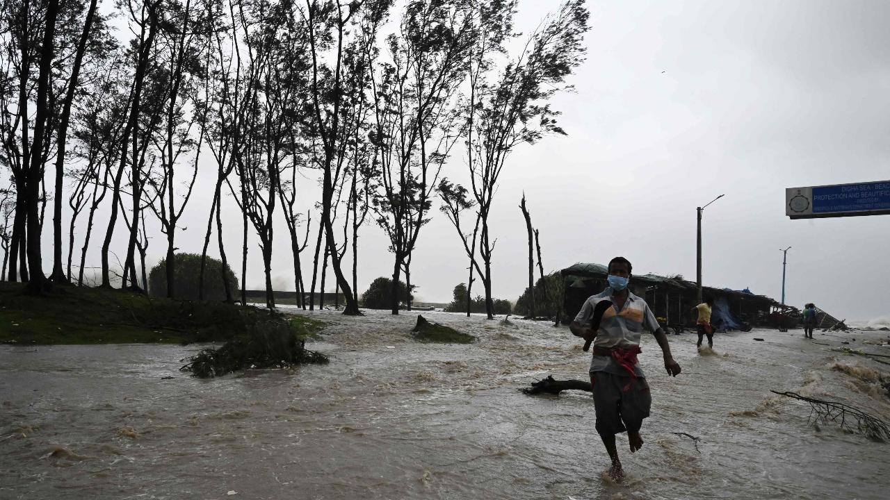Residents walk in a beachfront area as sea water reaches a nearby road while Cyclone Yaas makes the landfall. Credit: AFP Photo