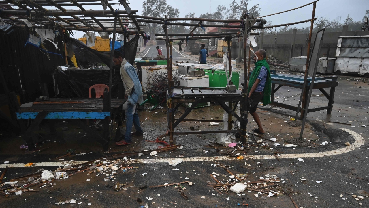 Residents shift their belongings from makeshifts stalls to a safer place while strong winds batter Balasore district in Odisha. Credit: AFP Photo