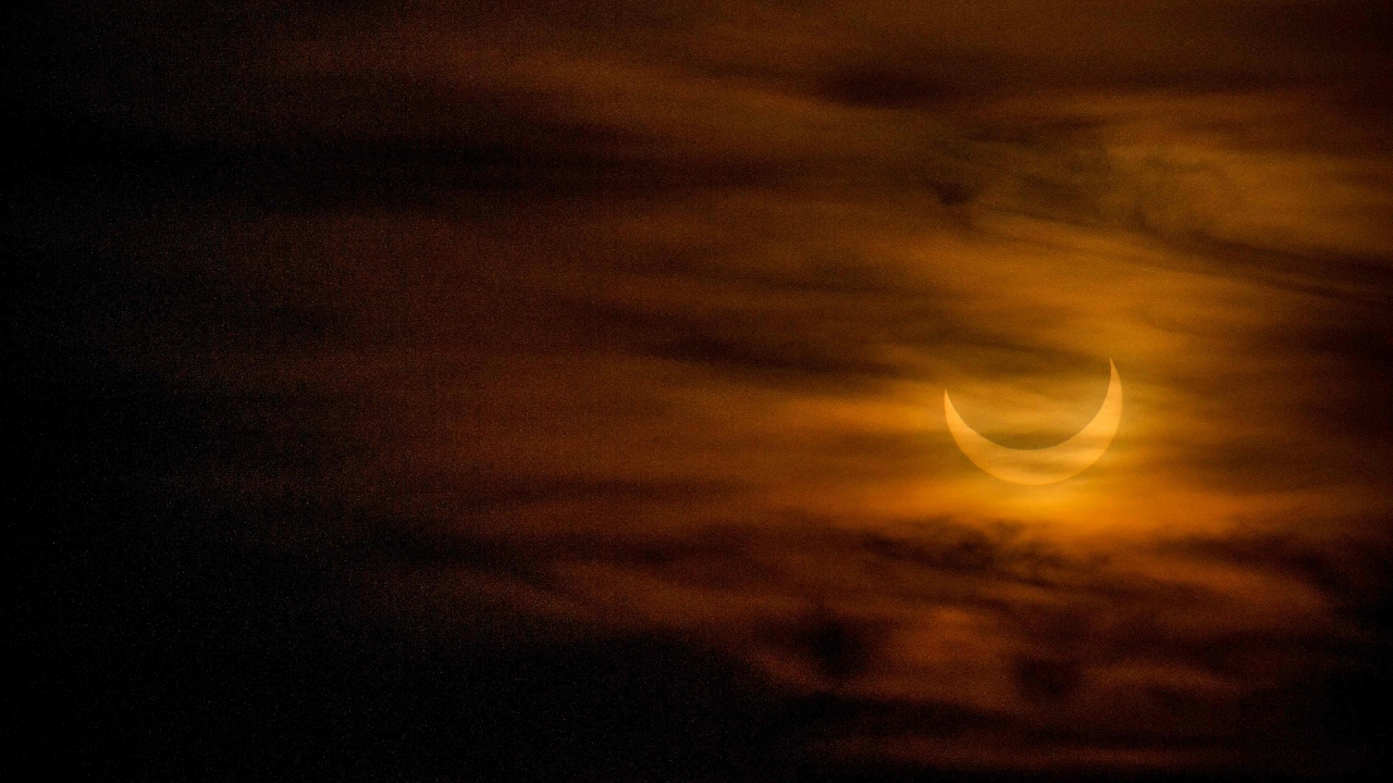 A annular (partial solar) eclipse is seen as the sun rises over Scituate Light in Scituate, Massachusetts. Credit: AFP Photo