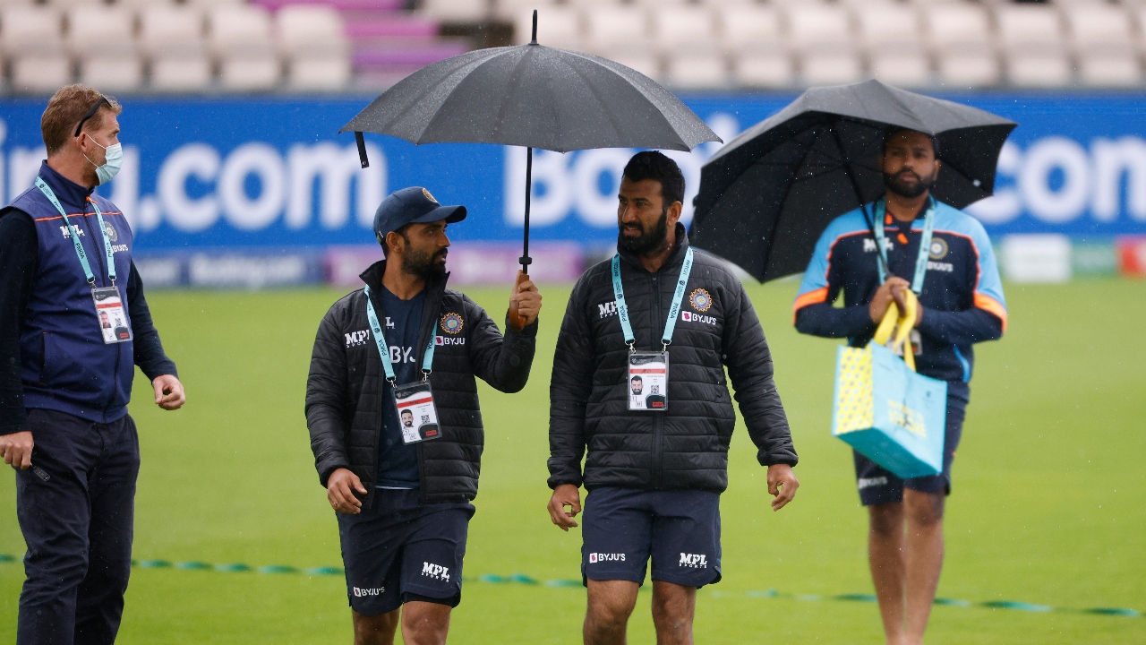 Ajinkya Rahane, Cheteshwar Pujara and Rohit Sharma walk on the field as rain stops the match. Credit: Reuters Photo