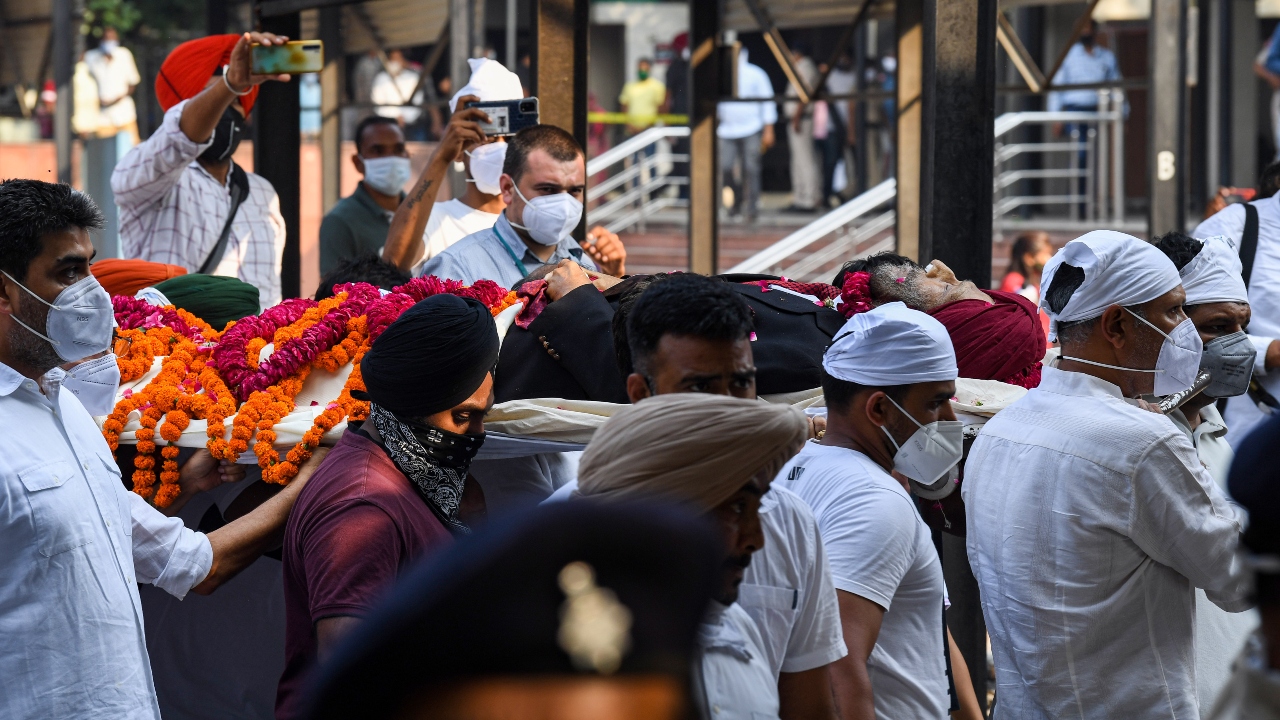 Earlier, the funeral procession started from Milkha's Sector 8 residence. His body was carried in a bedecked vehicle, with common people turning up along the short route to the Sector 25 cremation ground to pay their last respects to the legend. Credit: PTI Photo