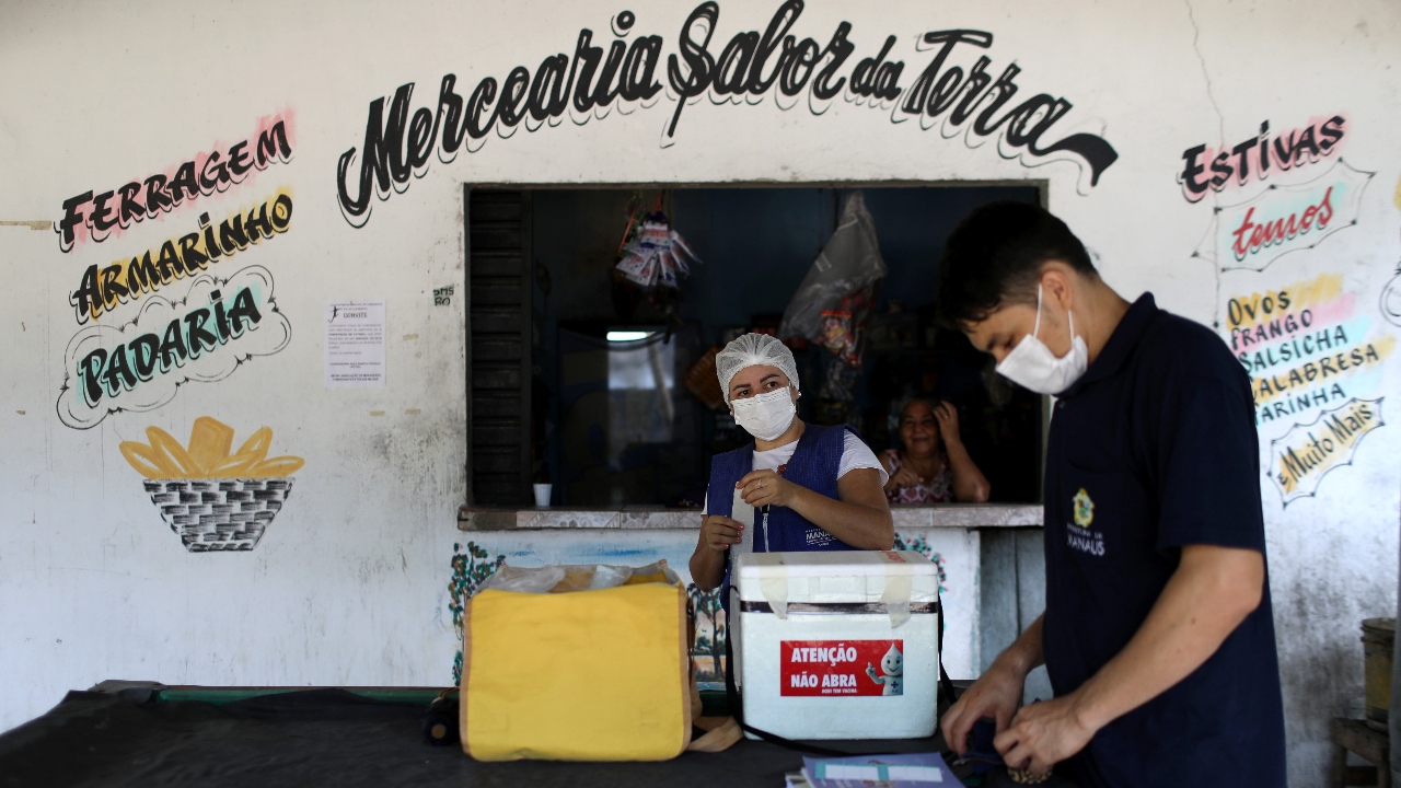 Municipal health worker Ana Cassia Oliveira de Lima and her colleague are seen along the Negro river banks, where Ribeirinhos (river dwellers) live, before inoculating people with the AstraZeneca Covid-19 vaccines at the Nossa Senhora do Livramento community, in Manaus, Brazil. Credit: Reuters Photo
