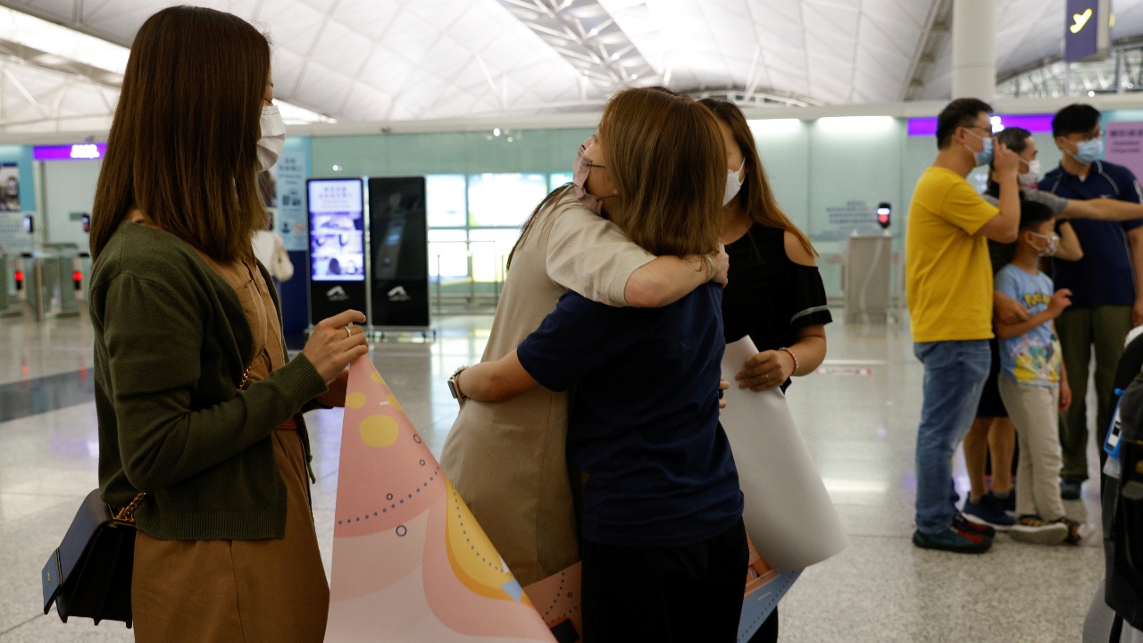 A woman hugs her friend as she leaves for United Kingdom.