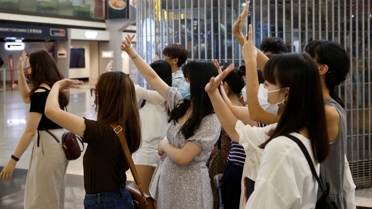 A group of people are seen bidding goodbyes to their friends going to United Kingdom at the Hong Kong International Airport.