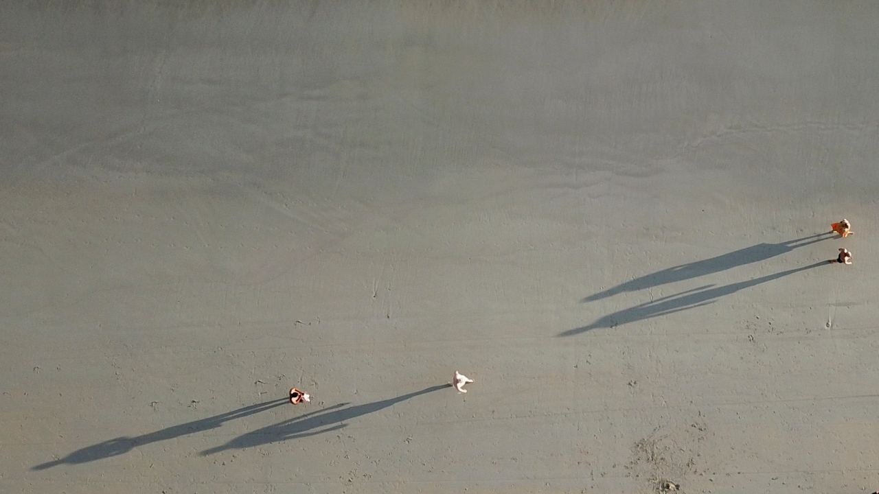 Tourists walk at the almost-empty Kata beach in Phuket.