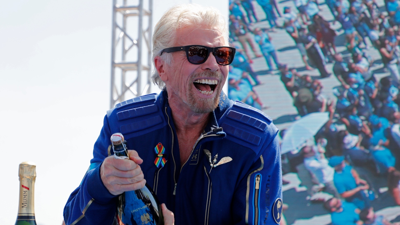 Richard Branson sprays champagne after flying with a crew in Virgin Galactic's passenger rocket plane VSS Unity. Credit: Reuters Photo