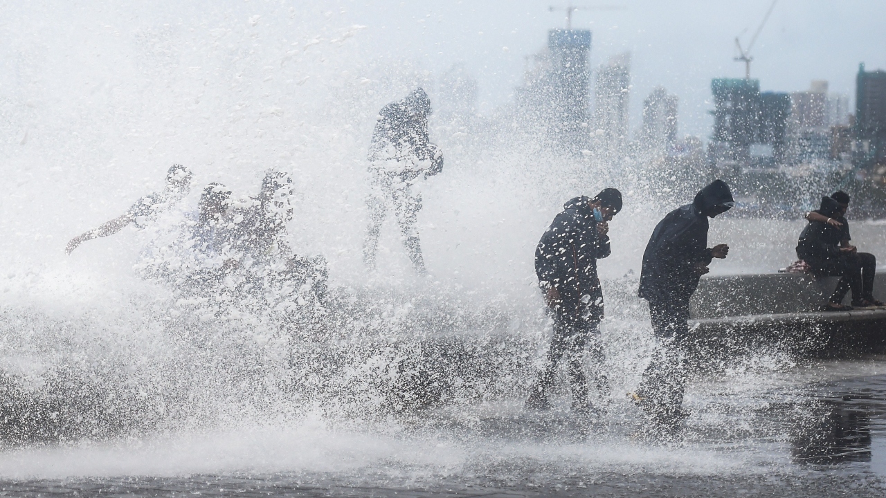 People get drenched in waves during monsoon rains at the Worli sea face in Mumbai. Credit: PTI Photo