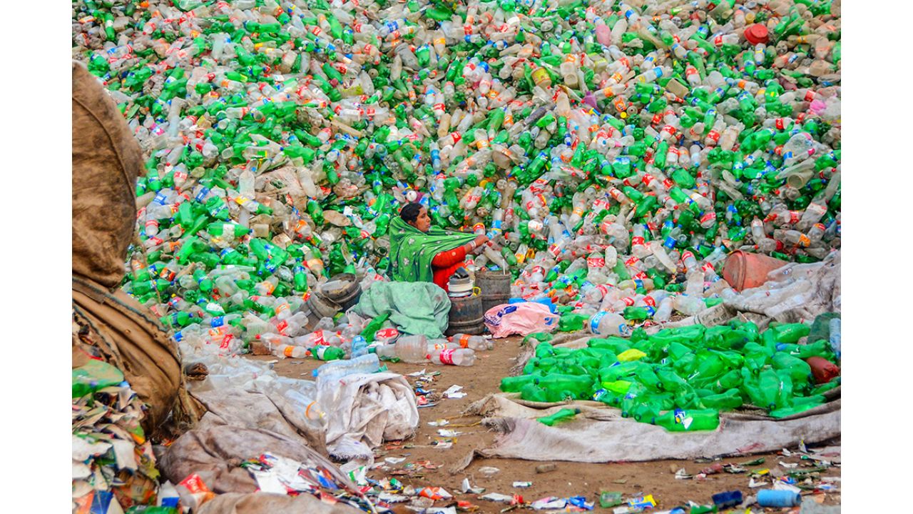 A woman scavenges for survival in a mountain of plastic waste, Pakistan. Photo by Sufyan Arshad (Pakistan)