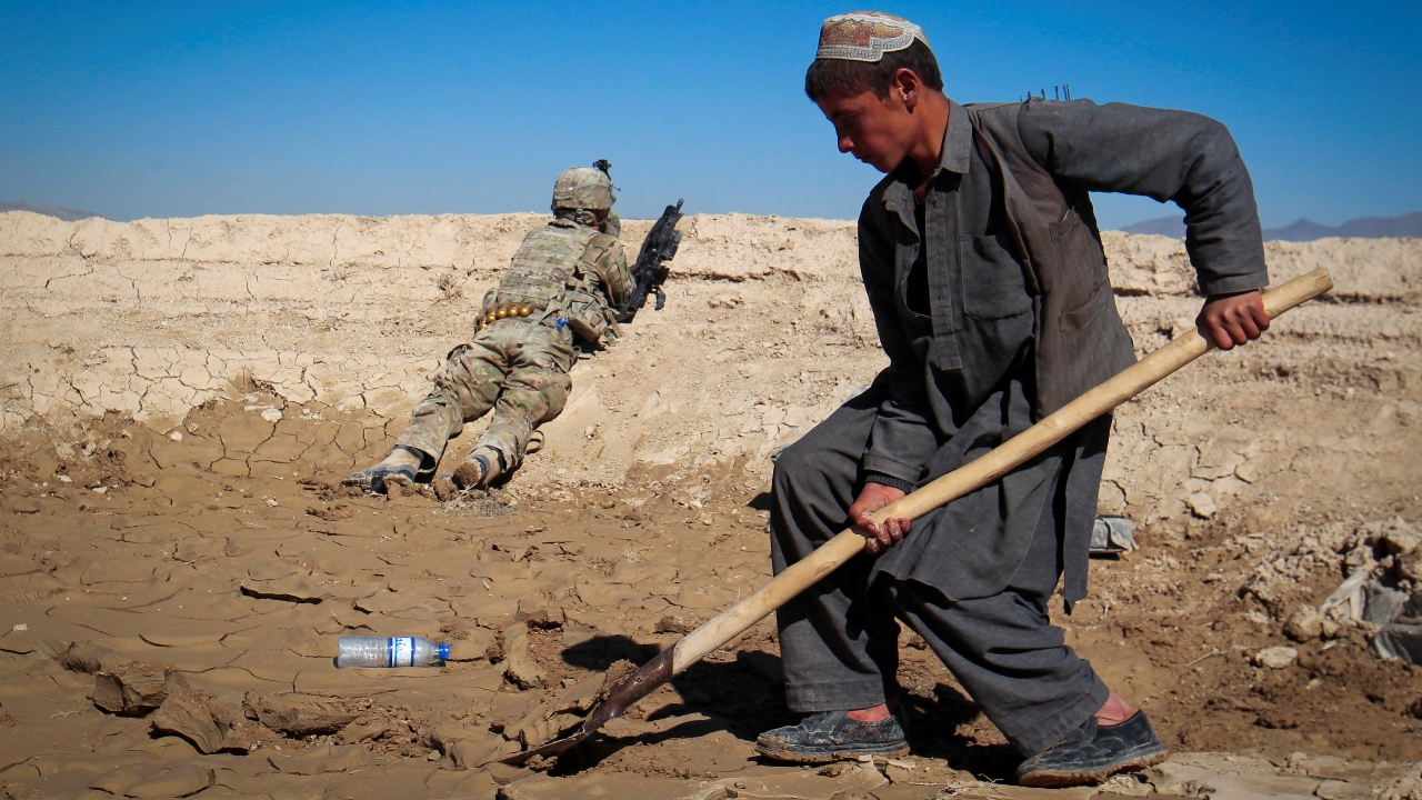 An Afghan boy works at a construction site as a US Army soldier of 3/1 AD Task Force Bulldog takes position during a joint patrol with Afghan National Army (ANA) in a village in Kherwar district in Logar province, eastern Afghanistan. Credit: Reuters Photo