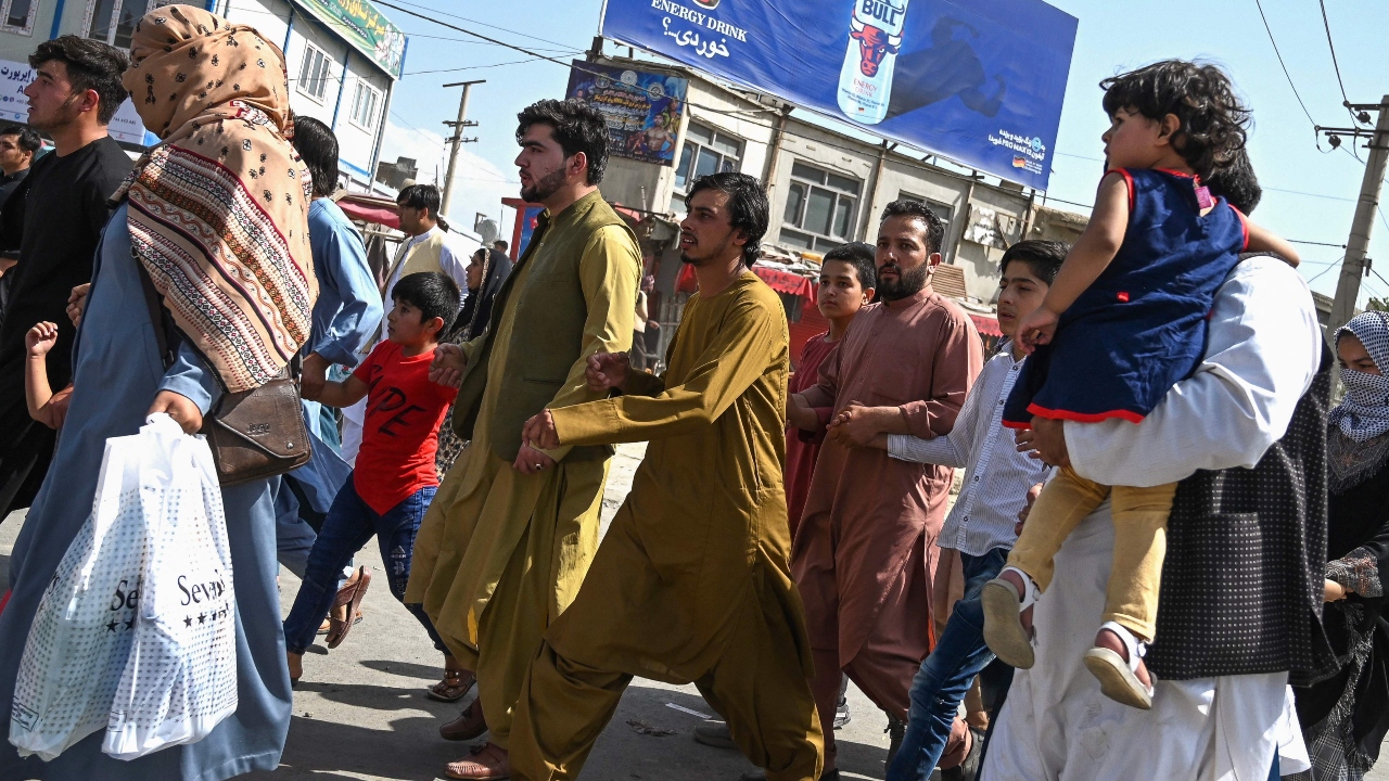 Afghan people run towards the Kabul airport to leave Kabul. Credit: AFP Photo