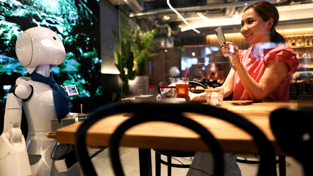 At a Tokyo Cafe, Michio Imai greets a customer, but not in person. He's hundreds of kilometres away, operating a robot waiter as part of an experiment in inclusive employment. Credit: AFP Photo