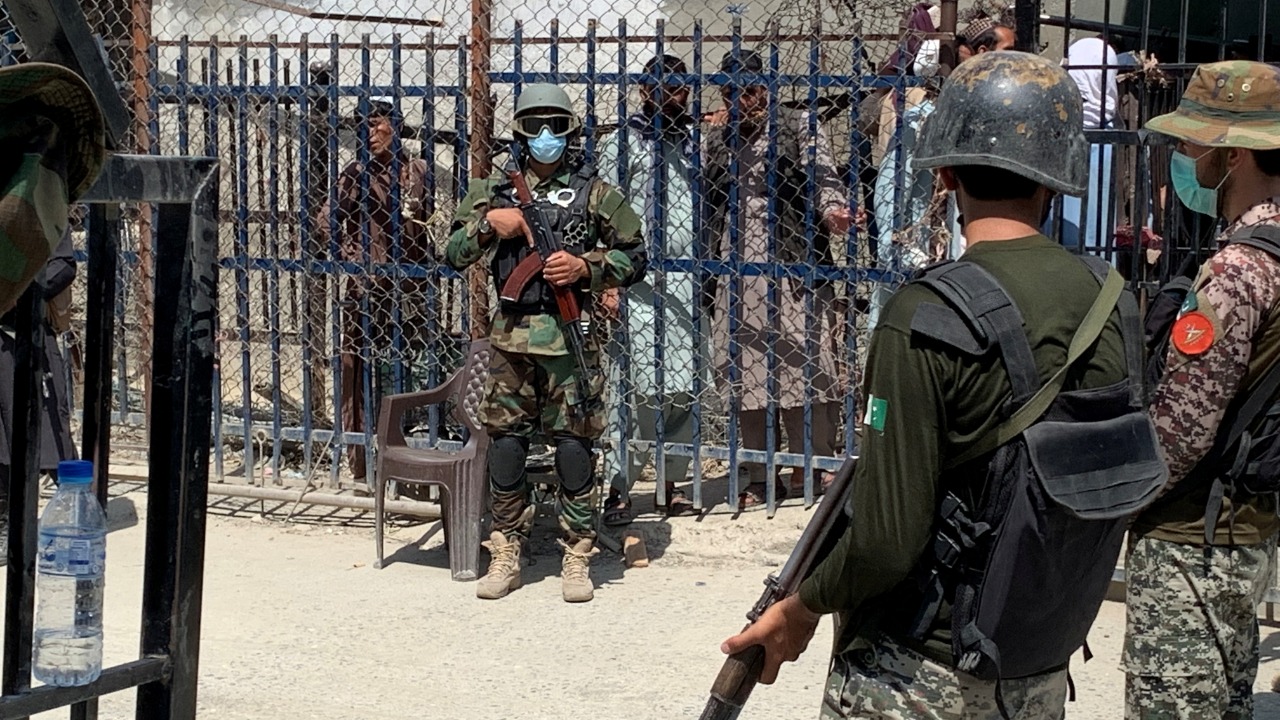 Pakistani soldiers stand guard in front of a member of the Taliban force, in the background, during an organised media tour to the Pakistan-Afghanistan crossing border, in Torkham. Credit: Reuters Photo
