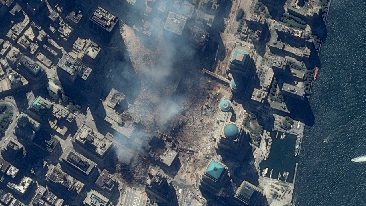 A man covering his mouth walks through dust and debris following the collapse of one of the twin towers of the World Trade Center in New York. Credit: AFP/File Photo