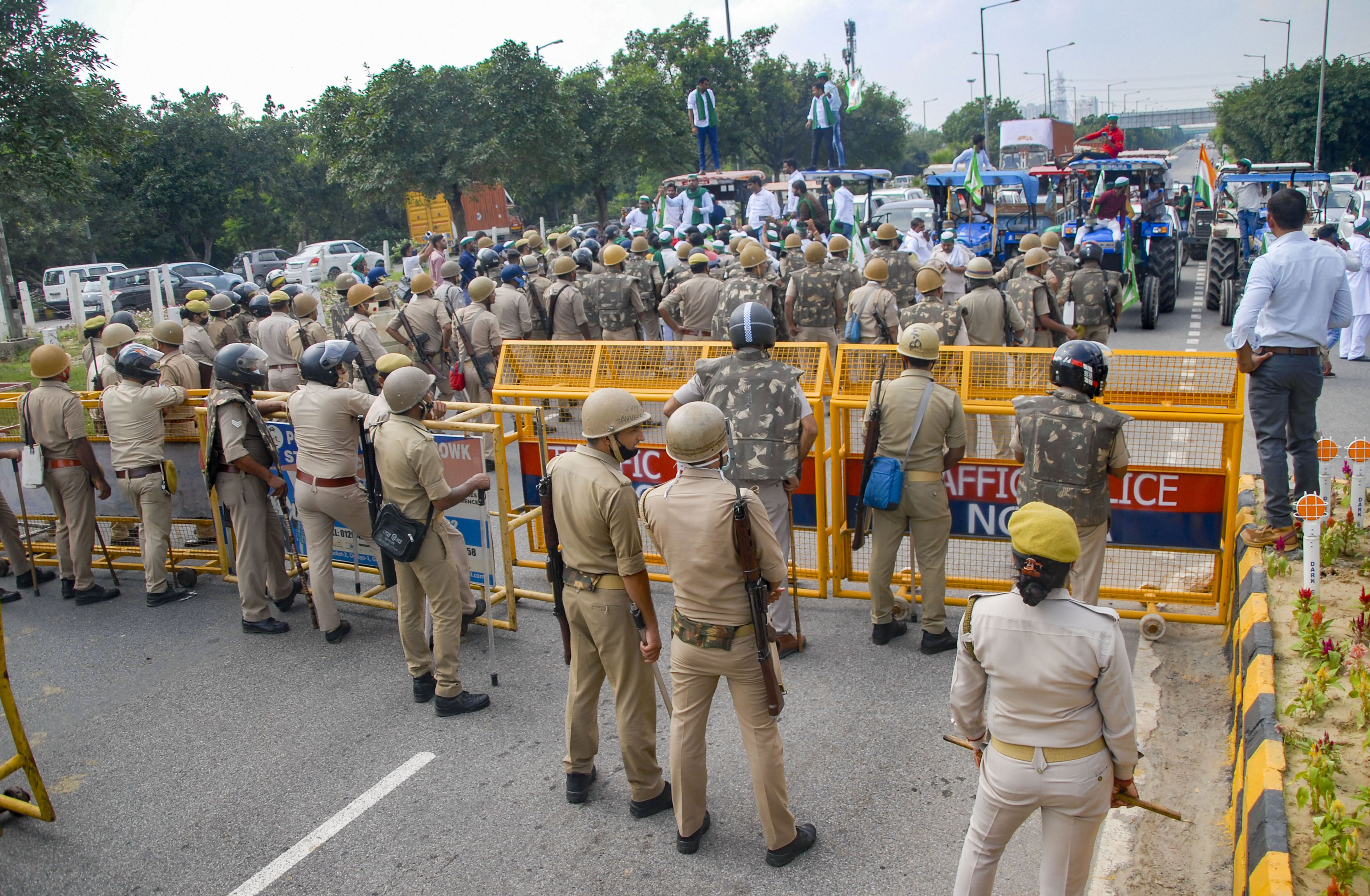 Police personnel put barricades to stop Bharatiya Kisan Union members during farmers' Bharat Bandh against the central government's three farm laws, in Noida. Credit: PTI Photo