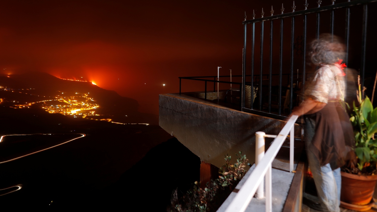 A woman watches from Tijarafe as lava flows into the sea following the eruption of a volcano on the Canary Island of La Palma, Spain. Credit: Reuters Photo