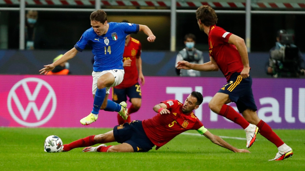 Italy's Federico Chiesa in action with Spain's Sergio Busquets. Credit: Reuters Photo