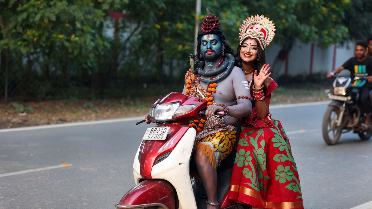 Lord of the road  Artistes dressed as Lord Shiva and Goddess Durga ride a scooter in Patna. Credit: PTI Photo