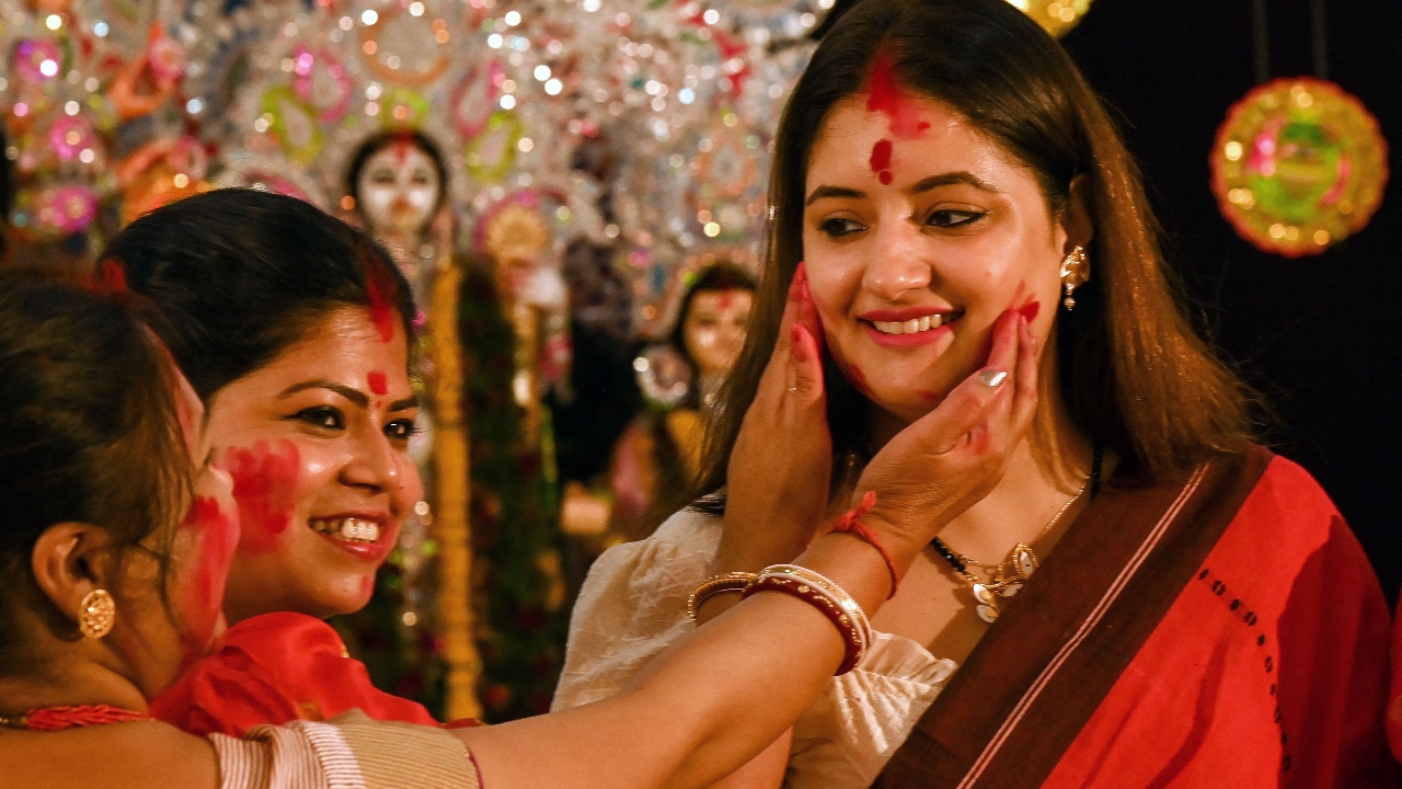 Women apply vermilion powder on each other as part of a traditional ritual on the last day of the Durga Puja festival in New Delhi. Credit: AFP Photo