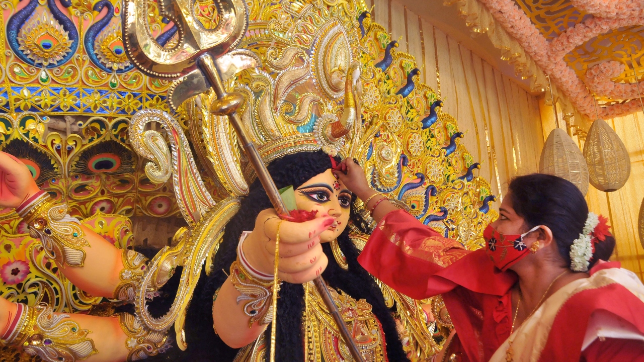 A woman devotee offers vermilion to Goddess Durga during 'Sindoor Khela' at a community puja pandal in Kolkata. Credit: PTI Photo