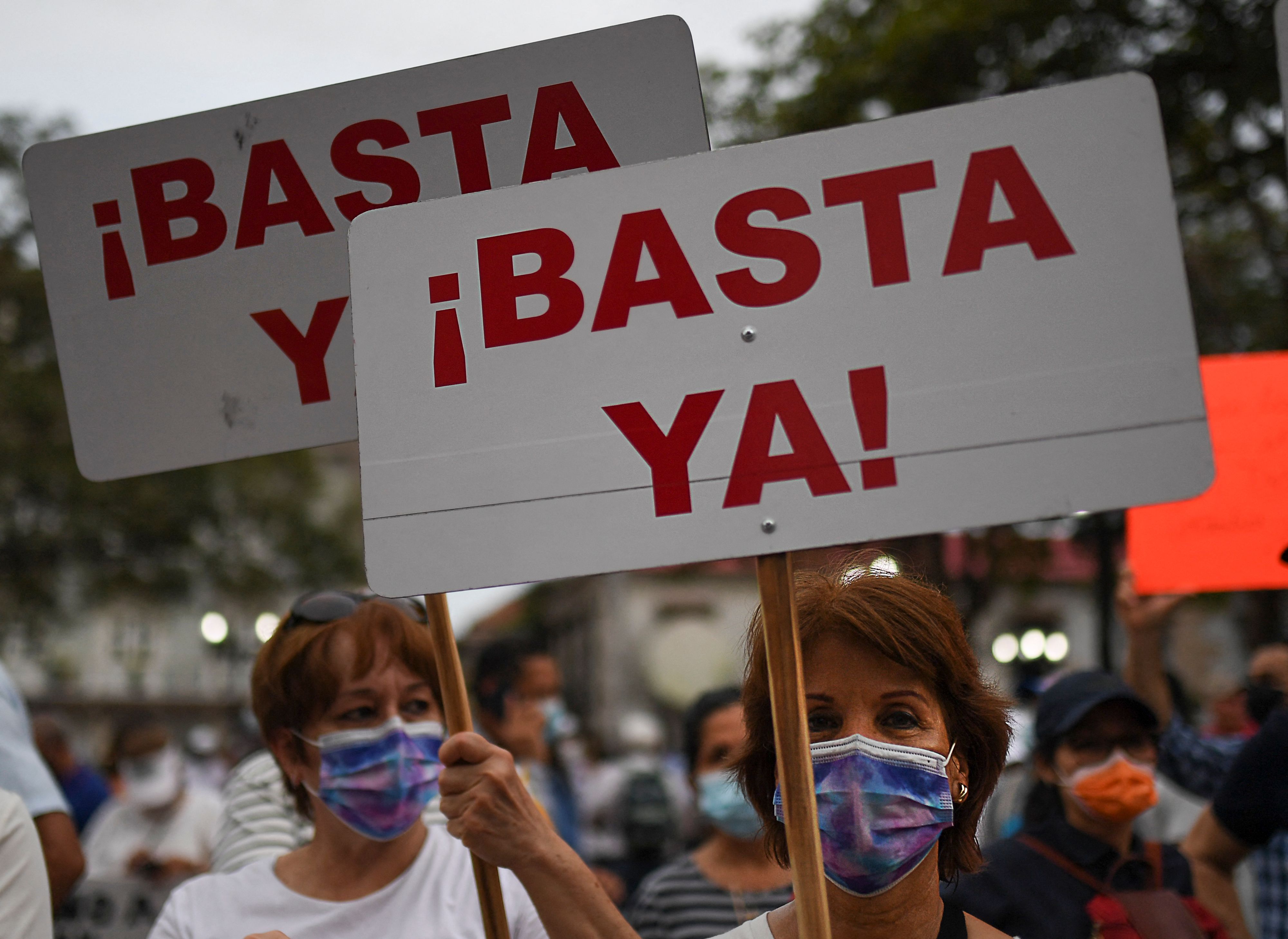 Demonstrator hold signs reading