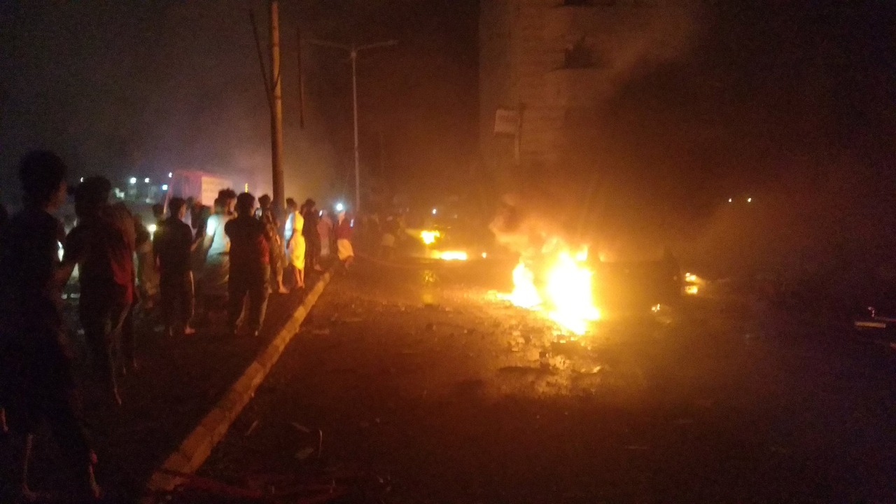 People look at cars on fire at the site of an explosion outside Aden international airport in Aden, Yemen. Credit: Reuters Photo