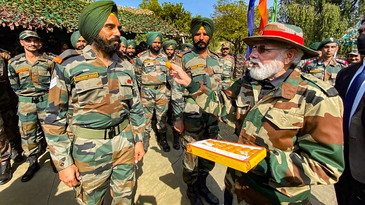 Prime Minister Narendra Modi can be seen offering sweets to soldiers. Credit: PMO