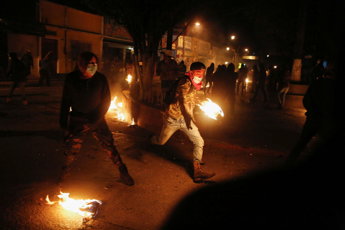 People kick flaming balls during the