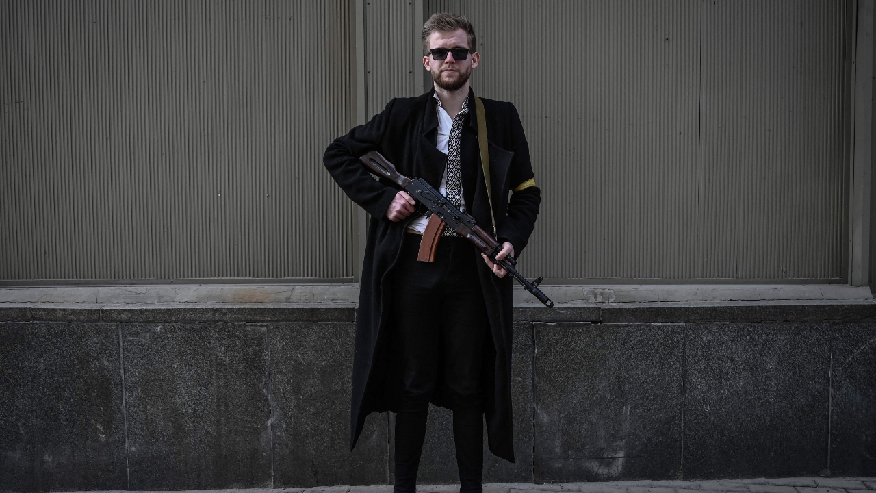A local poses with his assault rifle as he patrols downtown Kyiv, Ukraine. Credit: Reuters Photo
