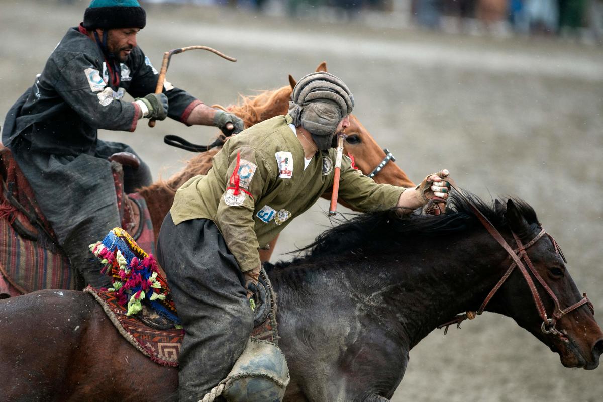 Horsemen from Kandahar team (L) and Kunduz team compete during the final of Afghanistan's Buzkashi League in Kabul. Credit: AFP Photo