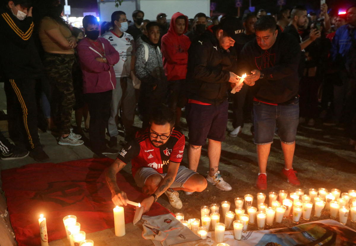 People and soccer fans take part in a prayer vigil after a clash between soccer fans during a match between Queretaro and Atlas in Queretaro left at least 22 people injured, outside Jalisco Stadium in Guadalajara, Mexico. Credit: Reuters Photo