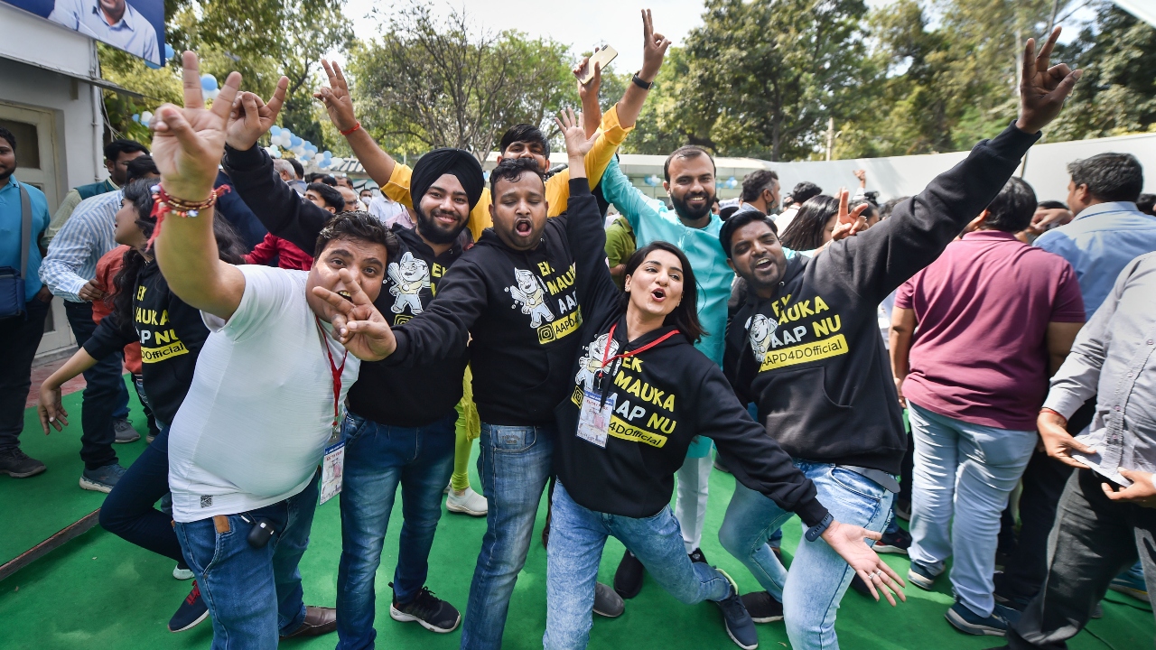 The joyous Aam Aadmi Party (AAP) supporters and workers pose for the photographs. Credit: PTI Photo