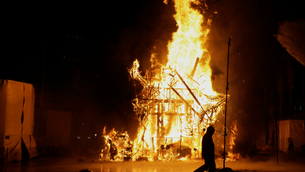 A fireman walks past a burning falla on the last day of the Fallas festival, in Valencia, Spain. Credit: Reuters Photo