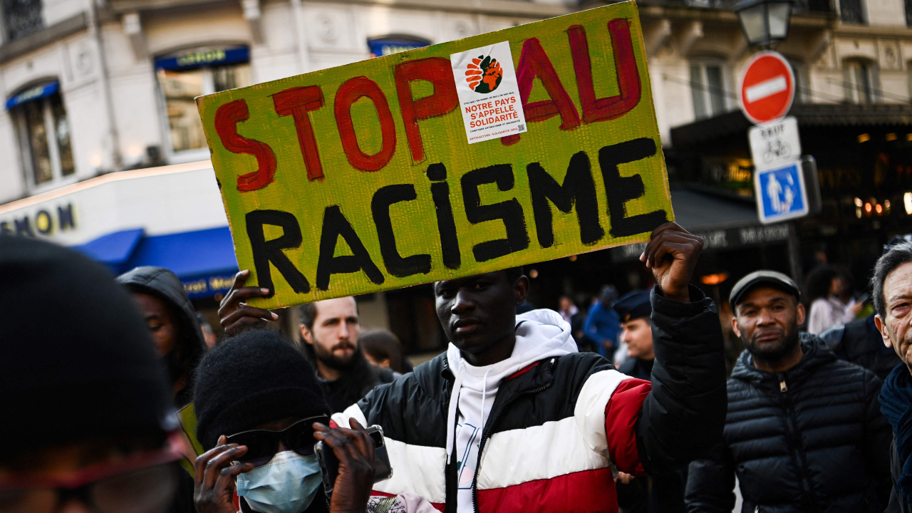 A man holds a sign reading