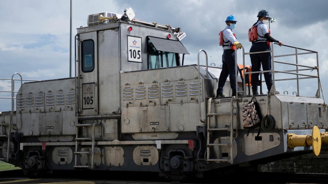 Workers ride a towing locomotive along the Panama Canal at the Miraflores Locks. Credit: Reuters photo