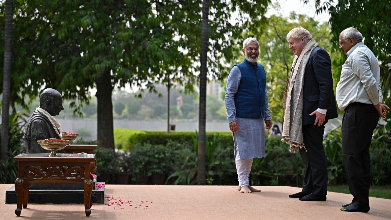 Johnson paid his tributes to Mahatma Gandhi during his visit to the Sabarmati Ashram. Also seen with him were India's environmental educator Kartikeya Sarabhai and the Gujarat chief minister Bhupendra Patel. Credit: AFP Photo
