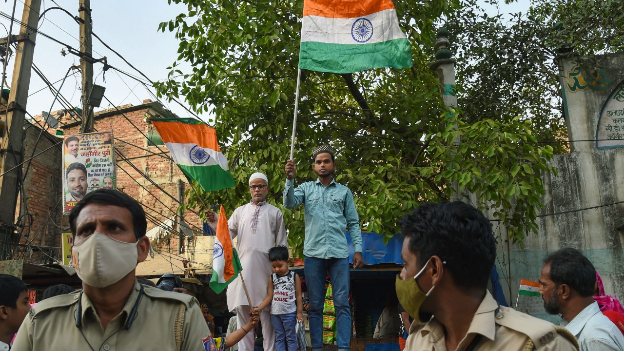 People wave the national flag during a 'Tiranga Yatra' taken out by members of both Hindu and Muslim communities, at the communal violence-hit Jahangirpuri area, in New Delhi. Credit: PTI Photo