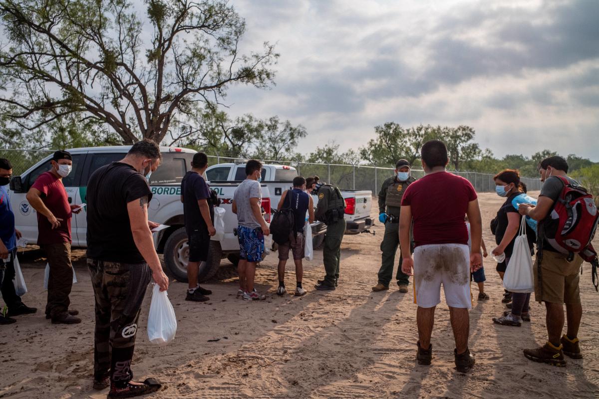 Migrants from Peru are processed by Border Patrol officers after crossing the Rio Grande into the US in Eagle Pass, Texas. Title 42, the controversial pandemic-era border policy enacted by former President Trump, which cites Covid-19 as the reason to rapidly expel asylum seekers at the US border, was set to officially expire on May 23rd. A federal judge in Louisiana delivered a ruling today blocking the Biden administration from lifting Title 42. Credit: AFP Photo