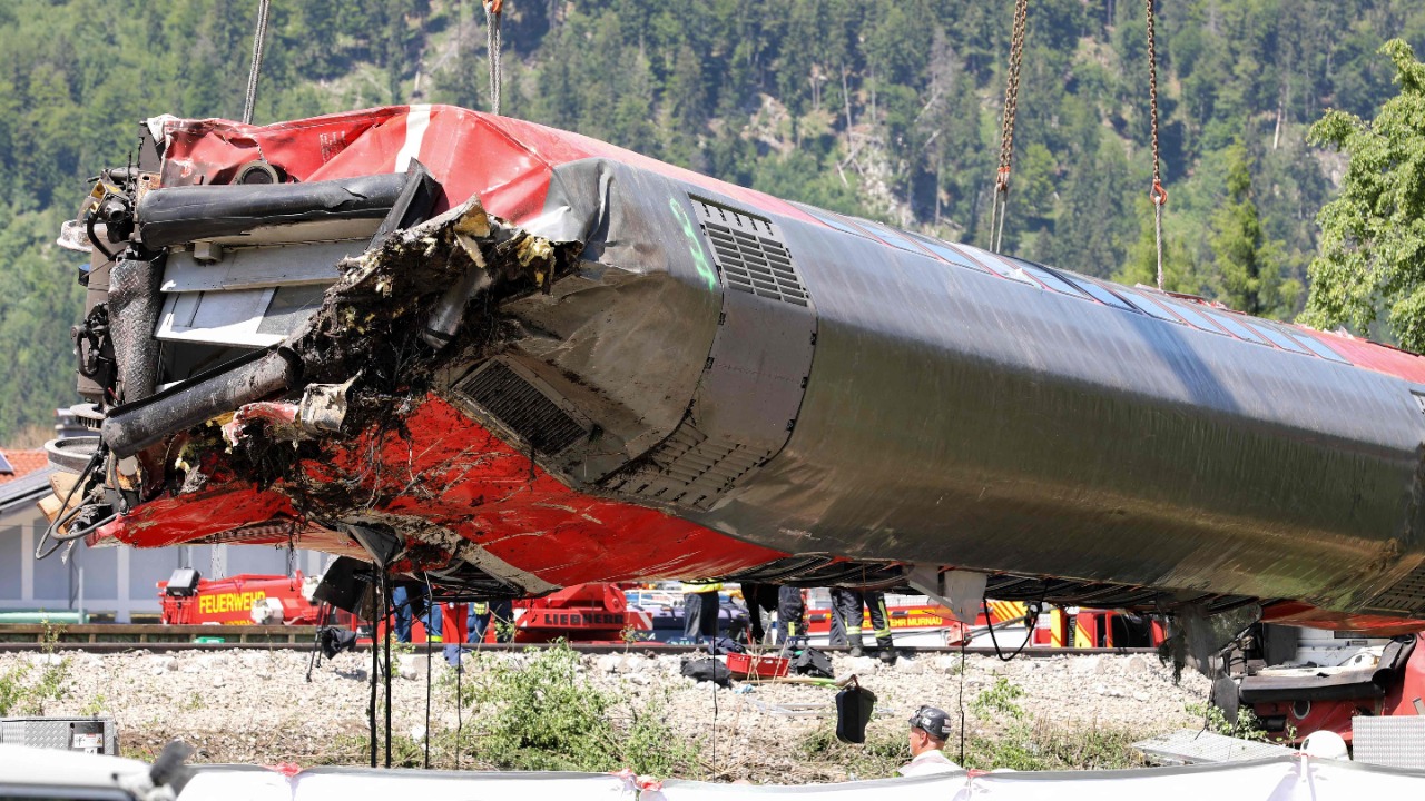 Workers use a crane to salvage a railway carriage at the site of a train derailment near Burgrain, north of Garmisch-Partenkirchen, southern Germany. Credit: AFP Photo