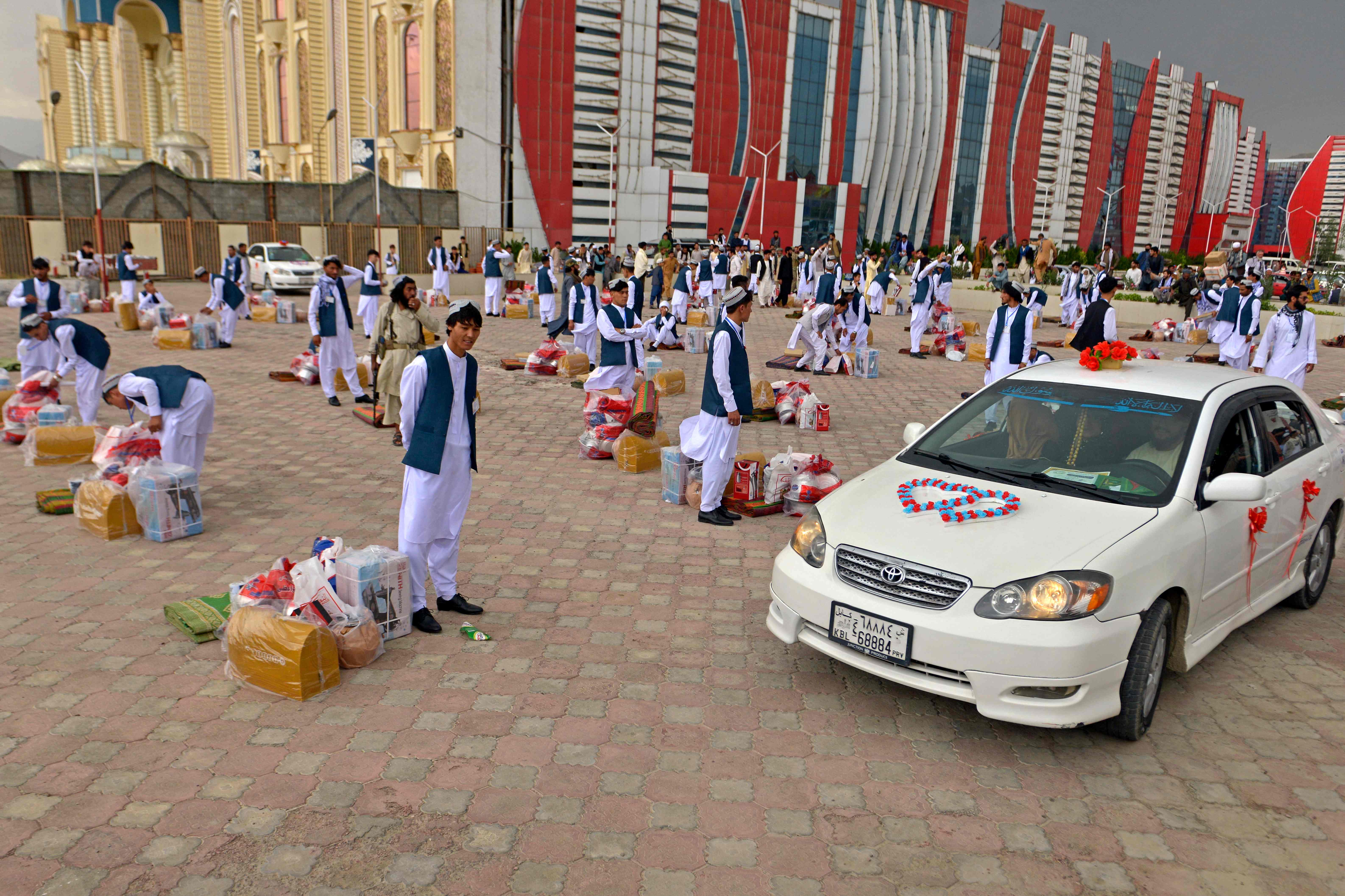 Grooms stand along with the gifts outside the wedding hall during a mass marriage ceremony. Credit: AFP Photo