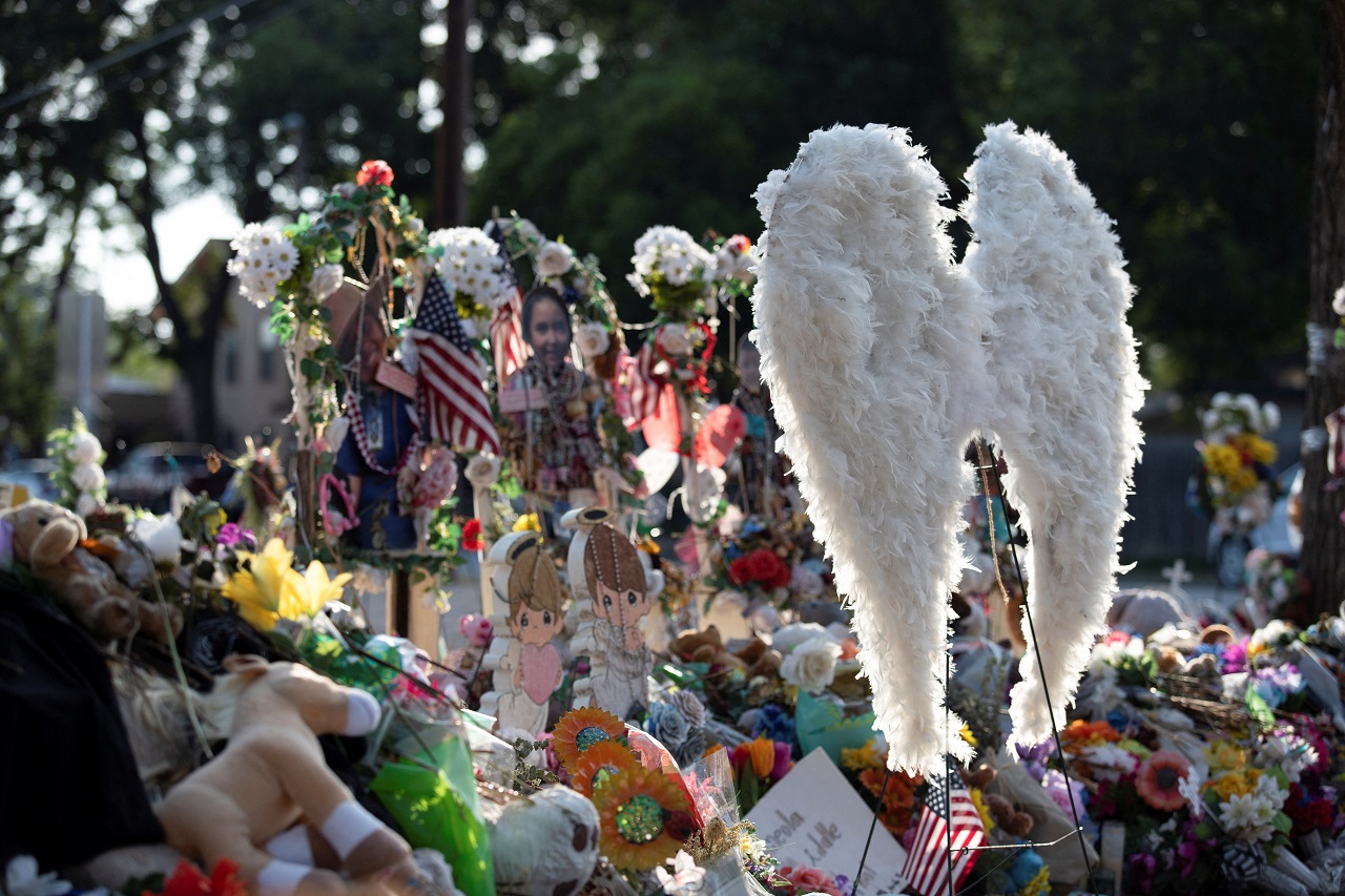 Feathered wings are placed amongst flowers at a memorial outside Robb Elementary School the day after the video showing the May shooting inside the school released. Credit: Reuters Photo