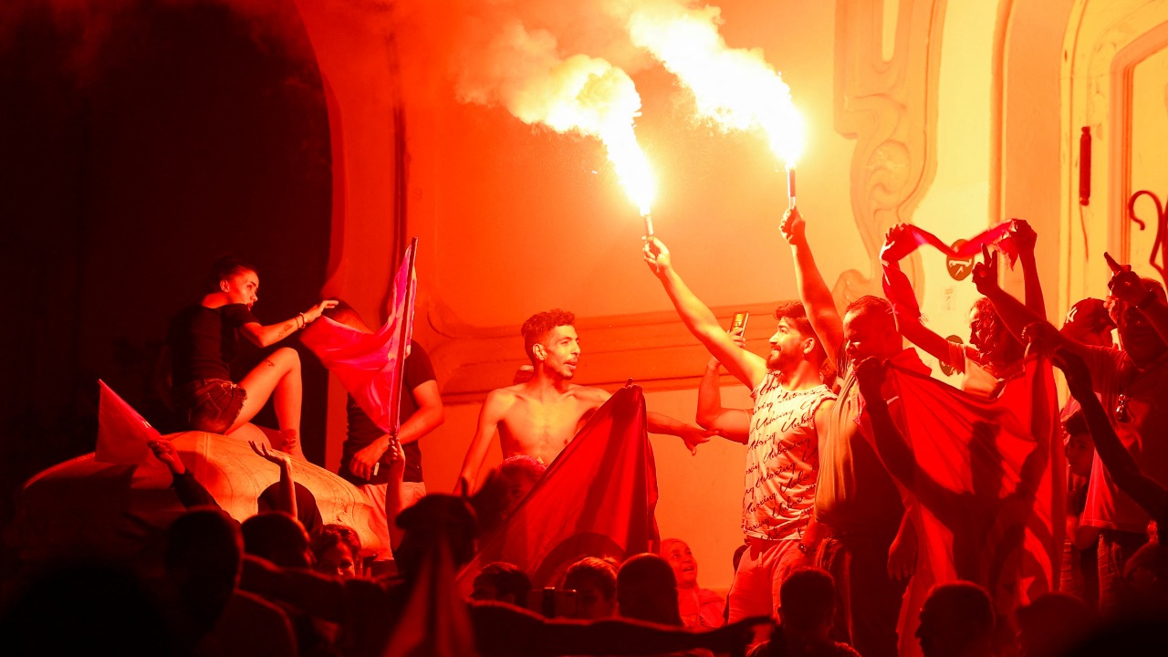 Supporters of president Kais Saied light flares as they celebrate after exit poll indicates voters backed new constitution in Tunis, Tunisia. Credit: Reuters photo
