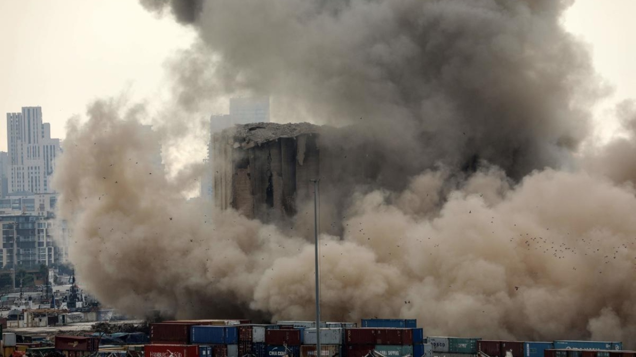 Heavy dust rises as part of the grain silos in the port of Beirut collapse, due to an ongoing fire since the beginning of last month, on August 4, 2022, on the day that crisis-hit Lebanon marks two years since a giant explosion ripped through the capital. Credit: AFP Photo