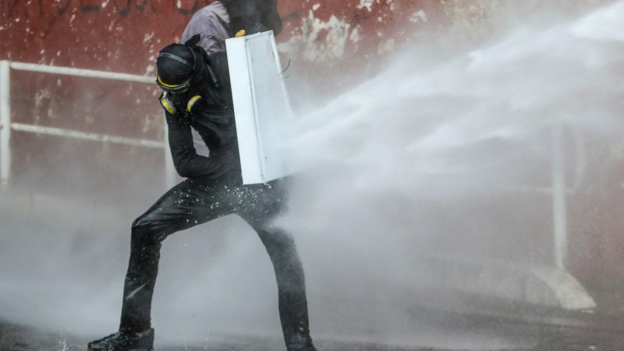 A demonstrator throws stones at riot police during a student protest in rejection of the government of President Ivan Duque, in Bogotá on August 4, 2022. Credit: Reuters Photo